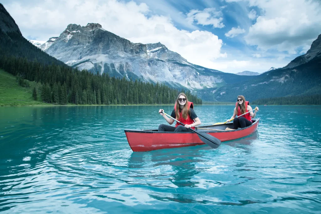Two people kayaking on tranquil lake.